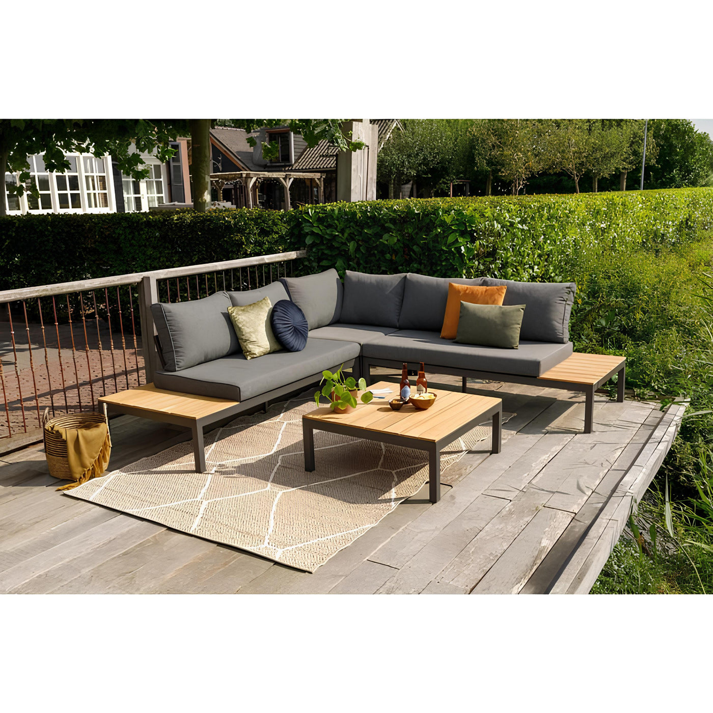 Garten mit Outdoor Lounge aus Holz und Metall mit grauen Sitzkissen und eckiger Couchtisch aus Metall und Holz